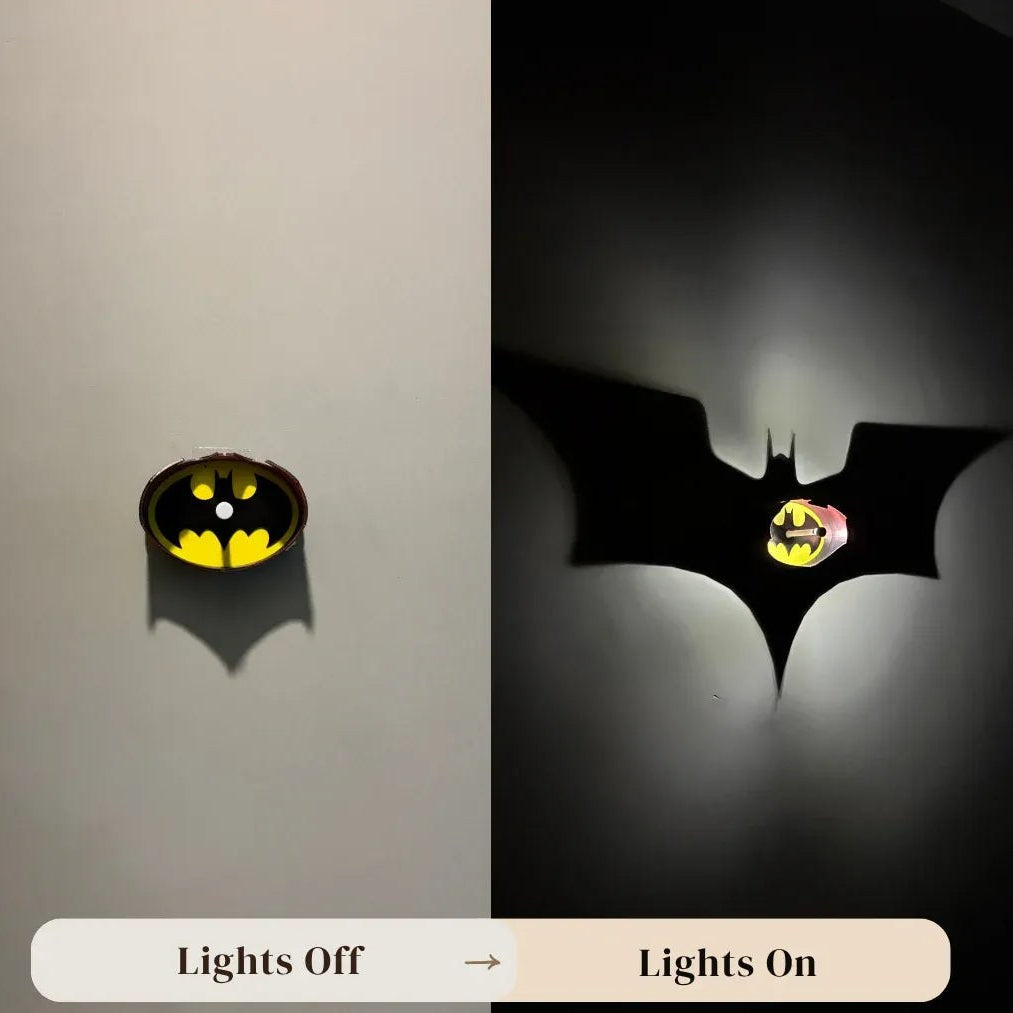 A split comparison showing a Batman logo wall light in two states: on the left, off with a small warm yellow glow inside the bat-shaped outline; on the right, on with a large black bat shadow投射 on a wall and a bright yellow light shining through the center. Text at the bottom reads 'Lights Off' and 'Lights On' with 'www.